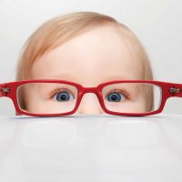 Child looking through red glasses